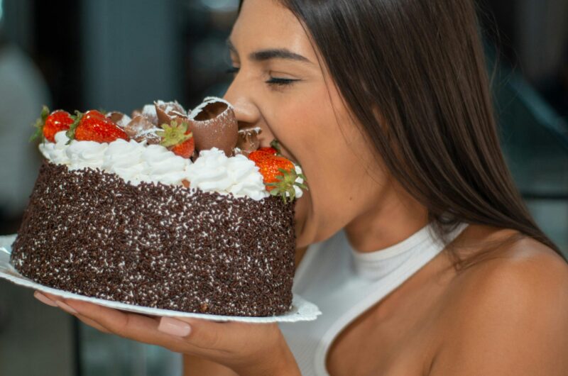 Woman Enjoying Chocolate Cake with Strawberries